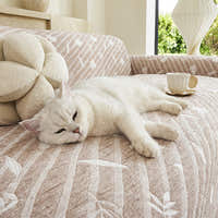 Close-up of Linen Beige Botanical Quilted throw with a white cat resting, showing the quilted leaf texture