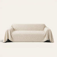 Breeze Lattice sofa throw in Ivory Pearl draped over a couch, front view on ivory background