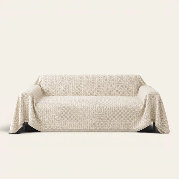 Breeze Lattice sofa throw in Ivory Pearl draped over a couch, front view on ivory background