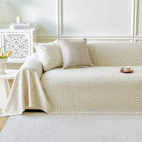 Ivory Pearl Breeze Lattice throw styled on a sofa with cushions in a bright living room