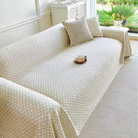 Breeze Lattice throw in Ivory Pearl over a sofa by a garden window with a cup and tulips