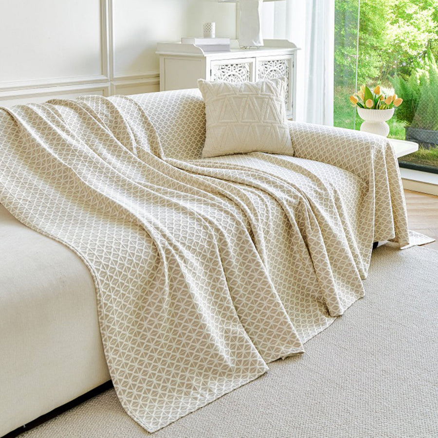 Ivory Pearl Breeze Lattice throw draped over a sofa arm by a bright window, side view
