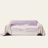 Lavender Drift Brushwave Chenille sofa throw draped over a two-seat sofa, front view on ivory background, pink fringed hem
