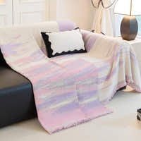 Lavender Drift Brushwave Chenille throw draped over the arm of a black leather sofa, flowing to the floor