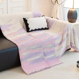 Lavender Drift Brushwave Chenille throw draped over the arm of a black leather sofa, flowing to the floor