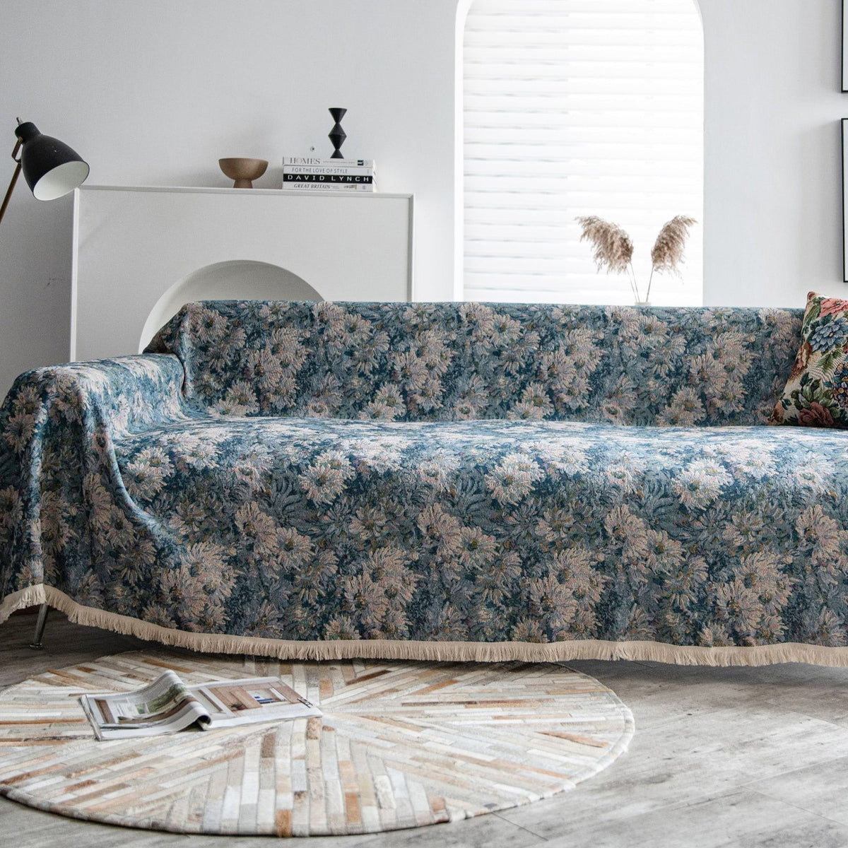 Blue Bouquet floral throw styled on a sofa with an arc lamp, console and pampas grass