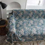 Overhead view of the Blue Bouquet Classic Floral throw draped across the sofa seat by a stool