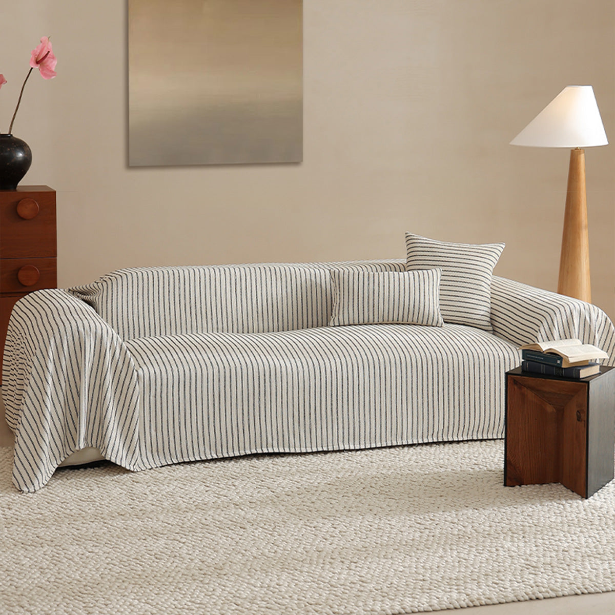 Charcoal Gray Classic Pinstripe throw covering a sofa in a bright living room with floor lamp, art and pink blooms
