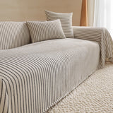 Charcoal Gray Classic Pinstripe throw over a sofa with matching pinstripe cushions, angled view by a window