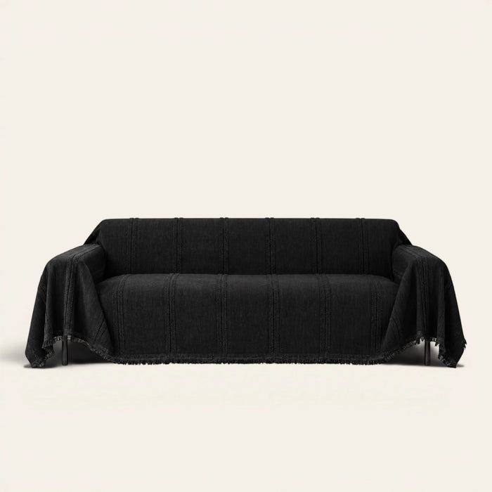 Ebony elegance Classic Striped sofa throw in black, draped over a couch on an ivory backdrop with fringe
