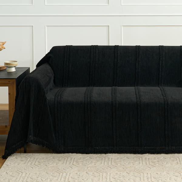 Ebony elegance Classic Striped black throw covering a sofa beside a wood side table, tufted stripe texture