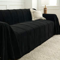 Angled view of the Classic Striped ebony elegance throw over a sofa with a cream boucle cushion