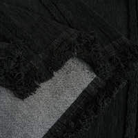 Detail of the ebony elegance Classic Striped throw's fringed corner folded over the sofa
