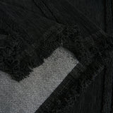 Detail of the ebony elegance Classic Striped throw's fringed corner folded over the sofa