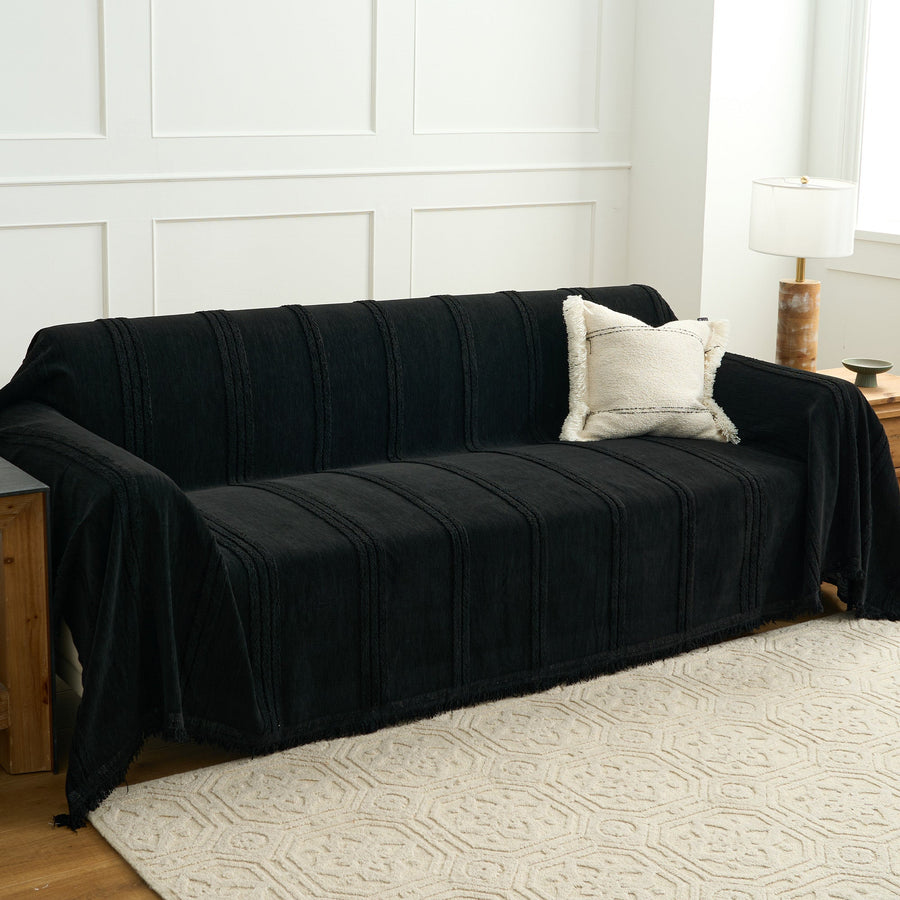 Ebony elegance Classic Striped black throw styled on a sofa in a bright room with a boucle cushion and lamp