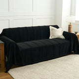 Ebony elegance Classic Striped black throw styled on a sofa in a bright room with a boucle cushion and lamp