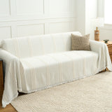 Ivory Whisper Classic Striped throw over a sofa in a paneled room, wide view with a patterned rug and lamp