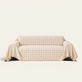 Cream multi Color Dot sofa throw draped over a couch, front view on an ivory backdrop with fringed edge