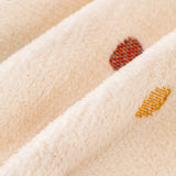 Macro close-up of the cream multi throw's soft woven texture and colorful polka dots