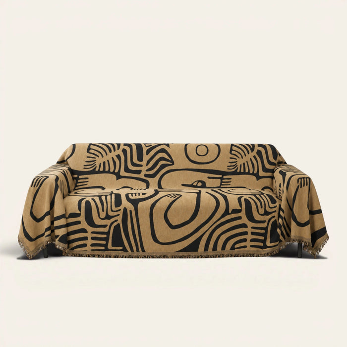 Ebony sand Contemporary Tribal sofa throw draped over a couch, front view on an ivory backdrop with fringe