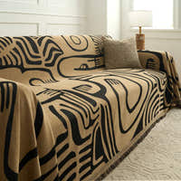 Ebony sand Contemporary Tribal throw draped over a couch showing bold black graphic motifs on sand
