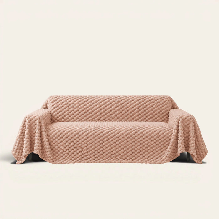 Cozy Chic sofa throw in Blush Pink over a couch, front view with a plush bubble textured surface