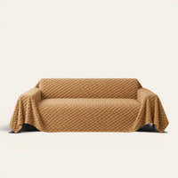 Cozy Chic sofa throw in Honeycomb Beige draped over a couch, front view on ivory background