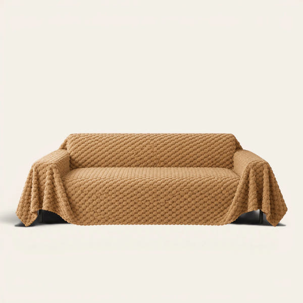 Cozy Chic sofa throw in Honeycomb Beige draped over a couch, front view on ivory background