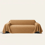 Cozy Chic sofa throw in Honeycomb Beige draped over a couch, front view on ivory background