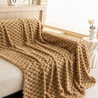 Cozy Chic throw in Honeycomb Beige draped over a sofa by a bright window with flowers