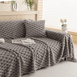 Slate Gray Cozy Chic throw over a sofa with cushion, book and coffee in a bright room