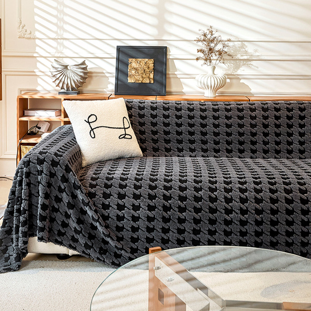 Charcoal Gray Cozy Houndstooth throw covering a sofa in a bright living room with wood console and line-art cushion