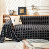 Charcoal Gray Cozy Houndstooth throw covering a sofa in a bright living room with wood console and line-art cushion