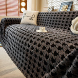 Charcoal Gray Cozy Houndstooth throw over a sofa, angled view with coffee cup and cushion showing plush texture