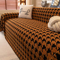 Coffee Brown Cozy Houndstooth throw covering a sectional sofa with line-art cushion and knot ball in a living room