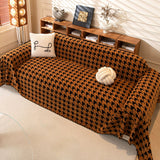 Overhead view of Coffee Brown Cozy Houndstooth throw on a sofa with cushion and knot ball beside wood shelving