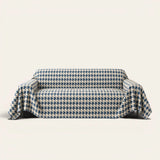 Cozy Houndstooth Ocean Blue sofa throw draped over a three-seat sofa, front view on ivory