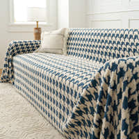 Cozy Houndstooth Ocean Blue throw draped over the sofa arm, angled view beside a lamp