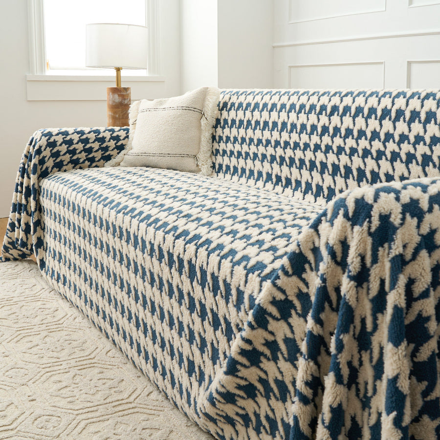 Cozy Houndstooth Ocean Blue throw draped over the sofa arm, angled view beside a lamp