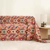 Scarlett Nomad kilim throw styled across a sofa beside a wood side table and lamp