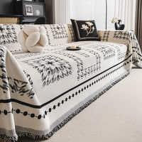 Ivory Ink Fringed Boho throw on a sofa with a fluffy cushion and floral pillow, angle view