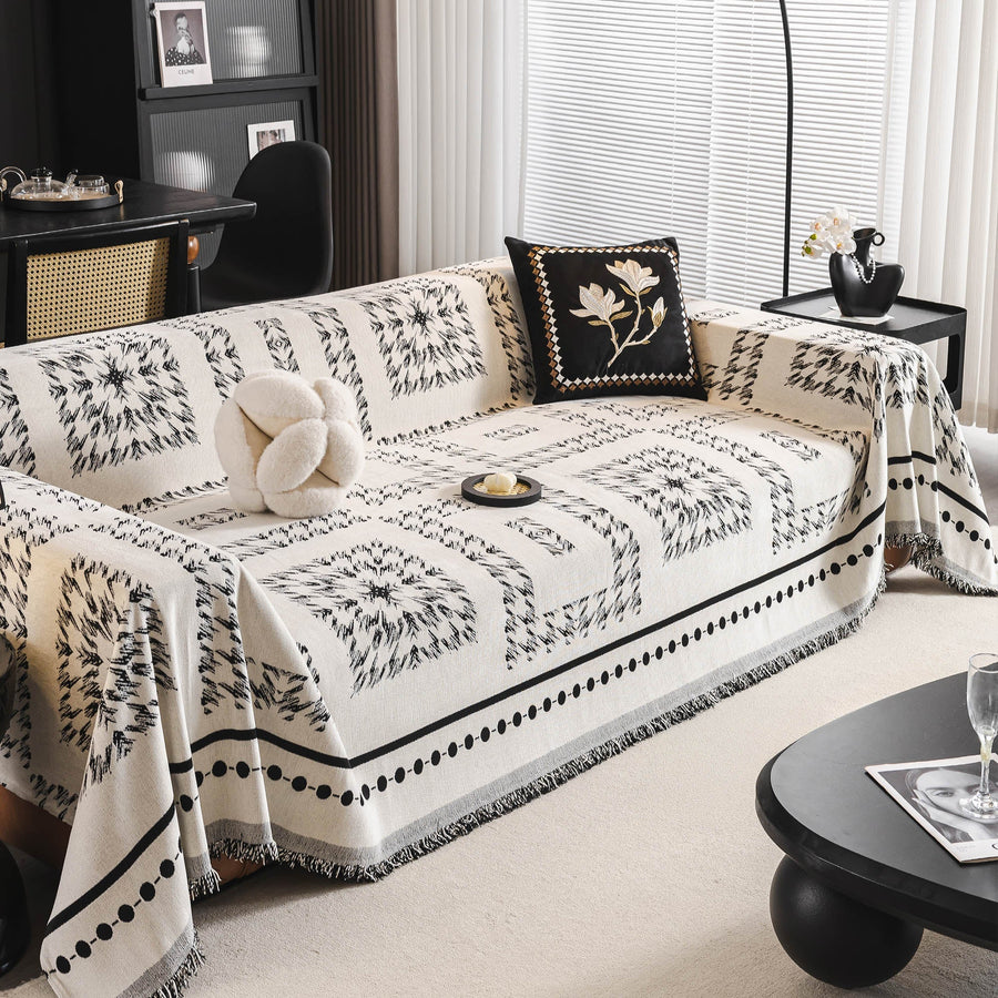 Fringed Boho throw in Ivory Ink styled on a sofa with pillows and a round coffee table