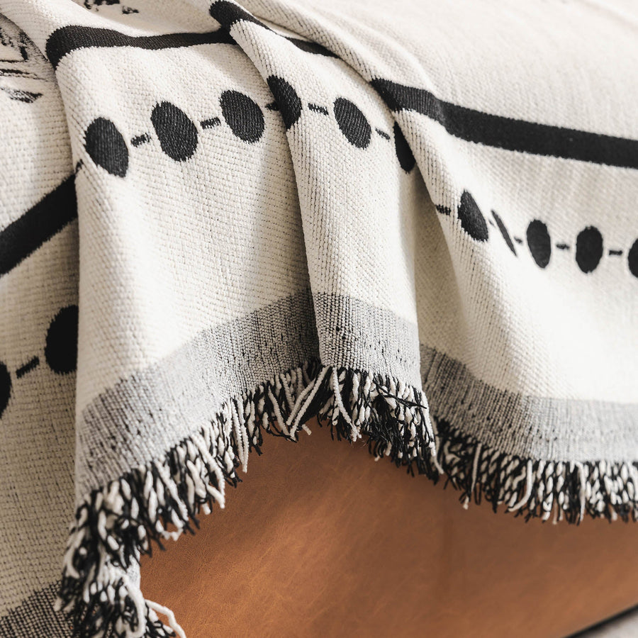Detail of the tasseled fringe edge of the Ivory Ink Fringed Boho throw