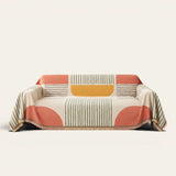 Citrus Burst Fruitopia sofa throw draped over a three seater sofa, front view on ivory background with colorful fringe