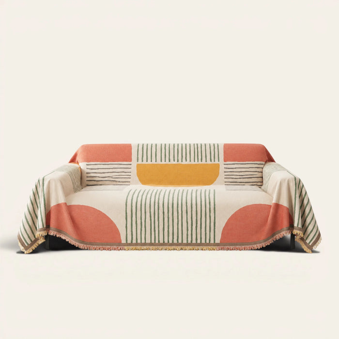 Citrus Burst Fruitopia sofa throw draped over a three seater sofa, front view on ivory background with colorful fringe