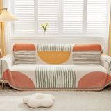 Citrus Burst Fruitopia throw covering a sofa by shuttered windows with floor lamp and flower cushion in a bright room