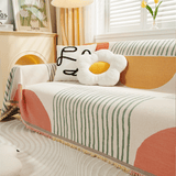 Angled view of Citrus Burst Fruitopia throw on a sofa with daisy cushion showing the sun and stripe pattern
