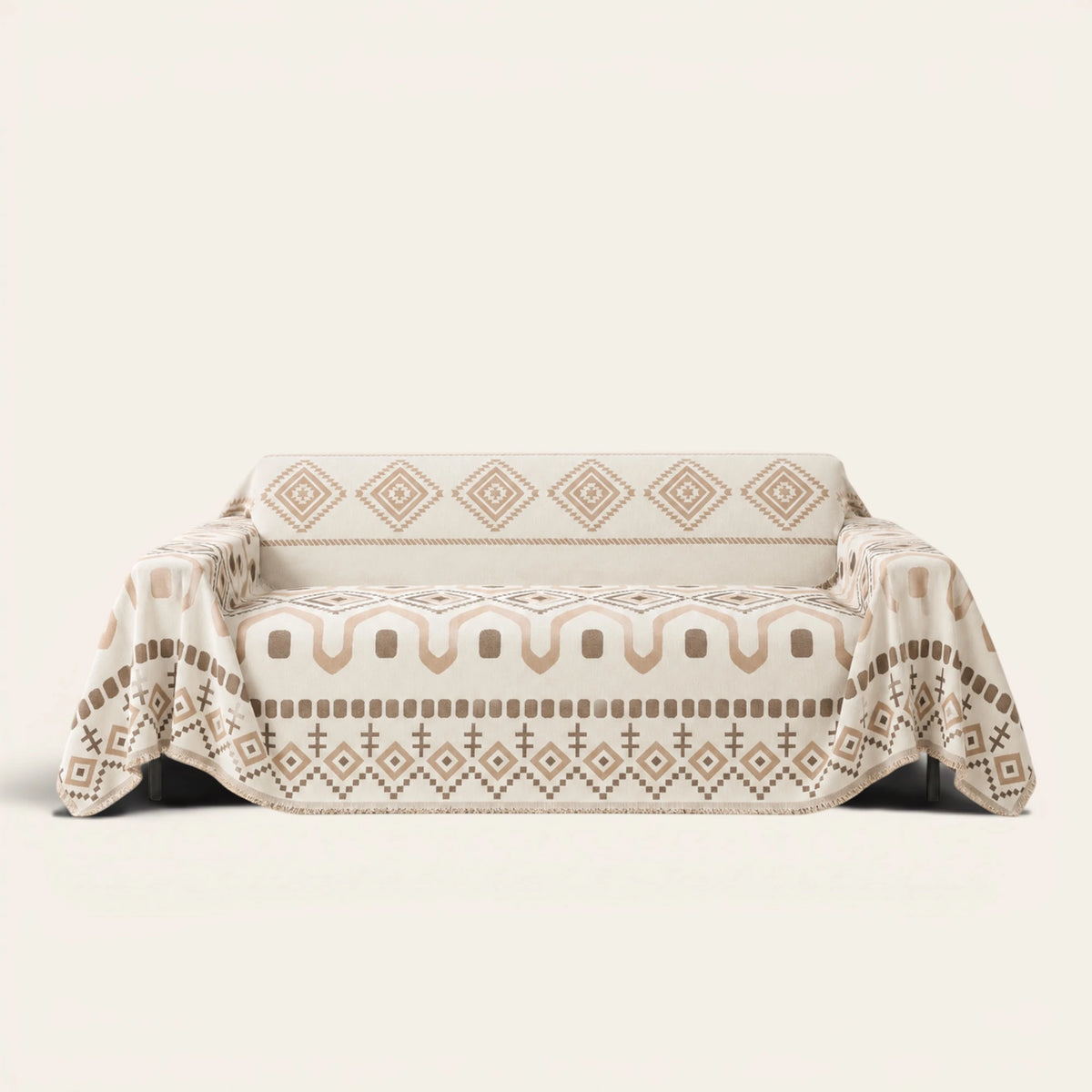Geometric Boho sofa throw in Beige Geometry draped over a couch, front view with aztec diamonds and fringe