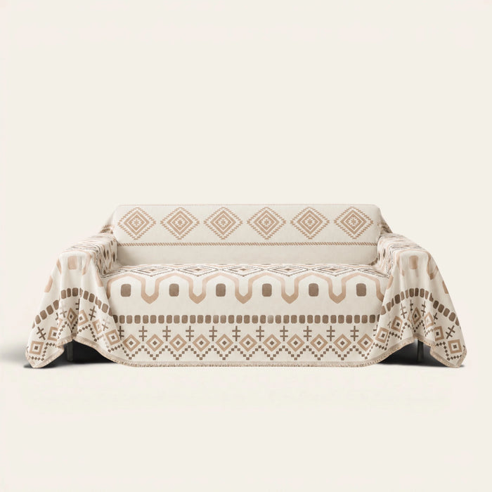 Geometric Boho sofa throw in Beige Geometry draped over a couch, front view with aztec diamonds and fringe