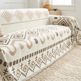 Beige Geometry throw draped across the sofa corner, showing the geometric pattern and fringed border